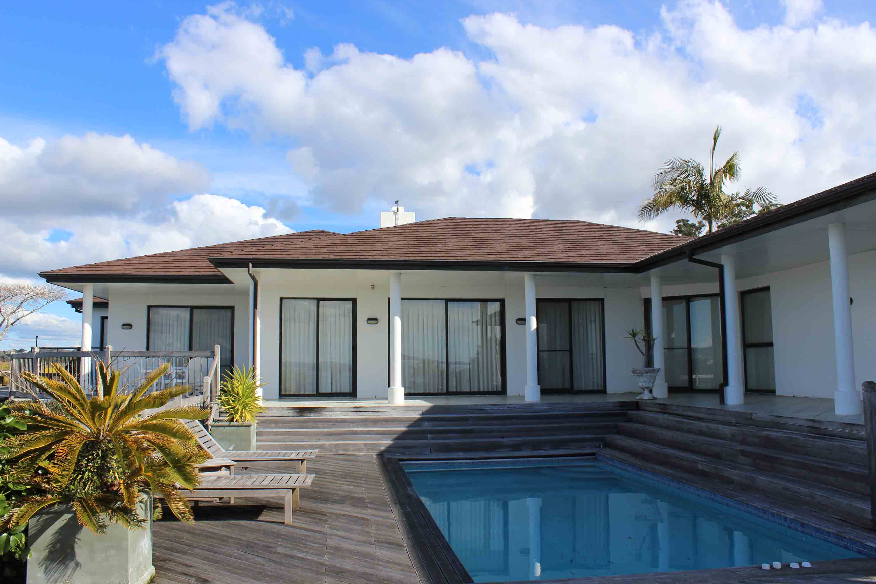 Looking back over the pool towards a home roofed with CF Slate steel roofing.