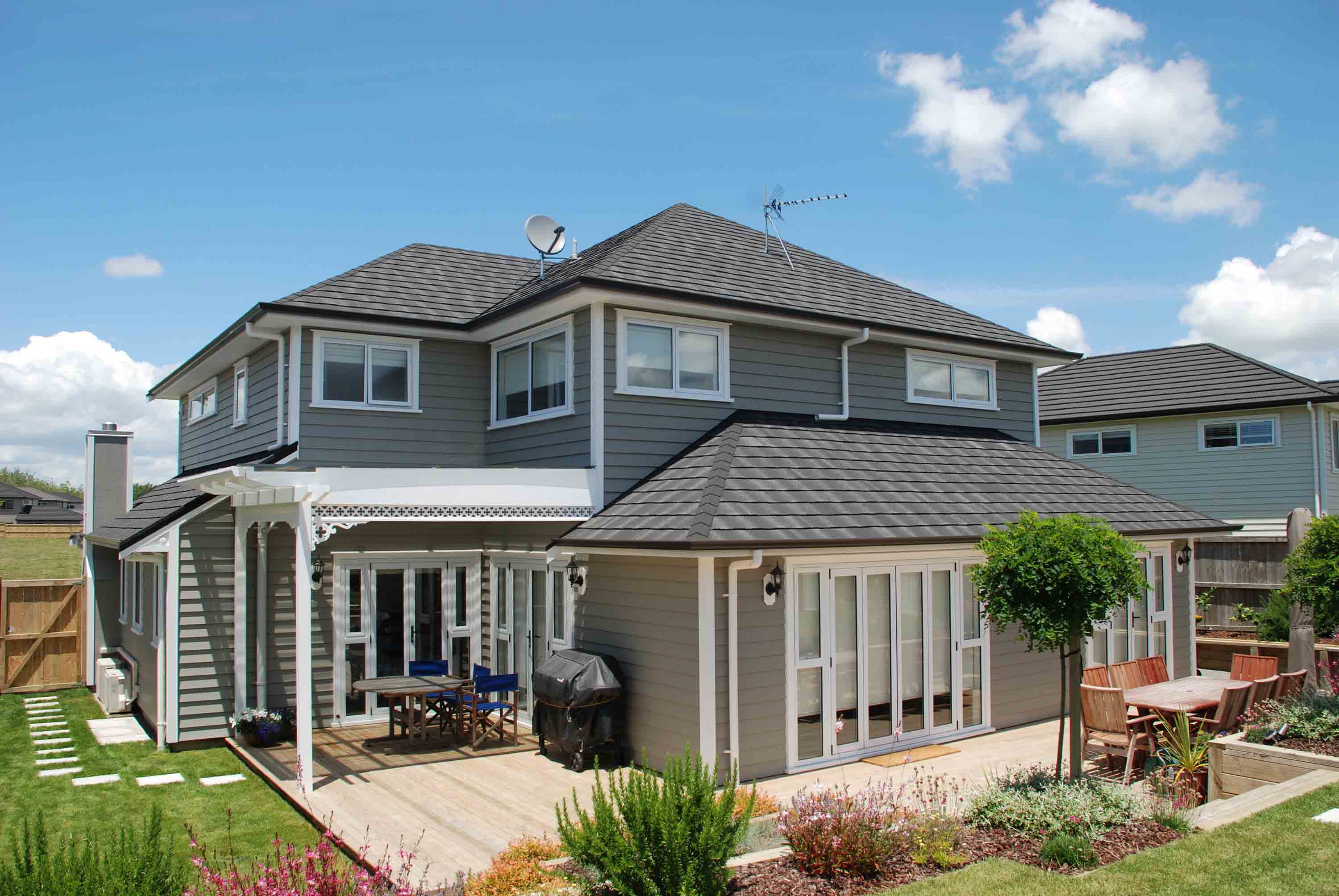 Grey weatherboard home with white joinery, featuring a CF Slate metal roof.