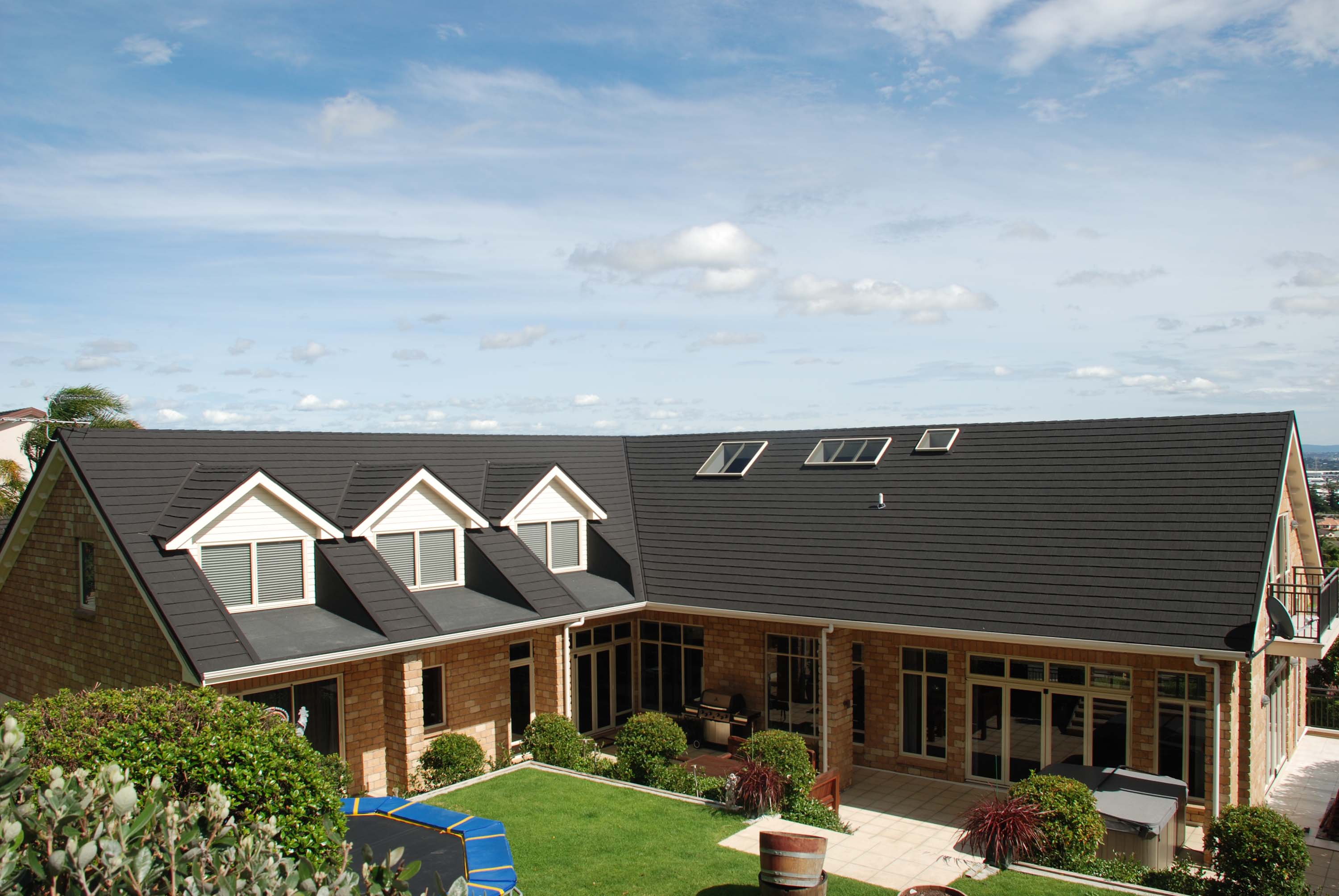 Brick house with CF Slate steel roof, view from the back yard.